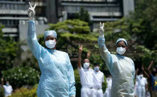 Hospital staff in Mumbai pay tribute to those involved in the fight against the spread of the coronavirus. Image by Manoej Paateel/Shutterstock. India, 2020.